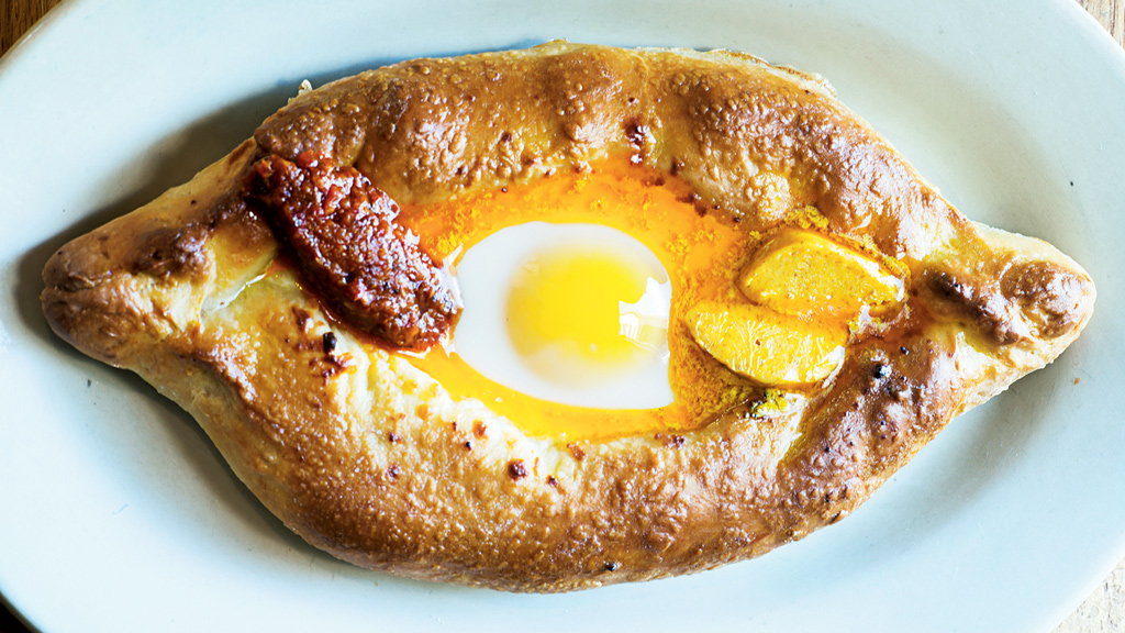 The Tasty Dug-Out's Khachapuri with marigold butter, brined cheese, and adjika, a red-pepper condiment. Photograph by Scott Suchman.