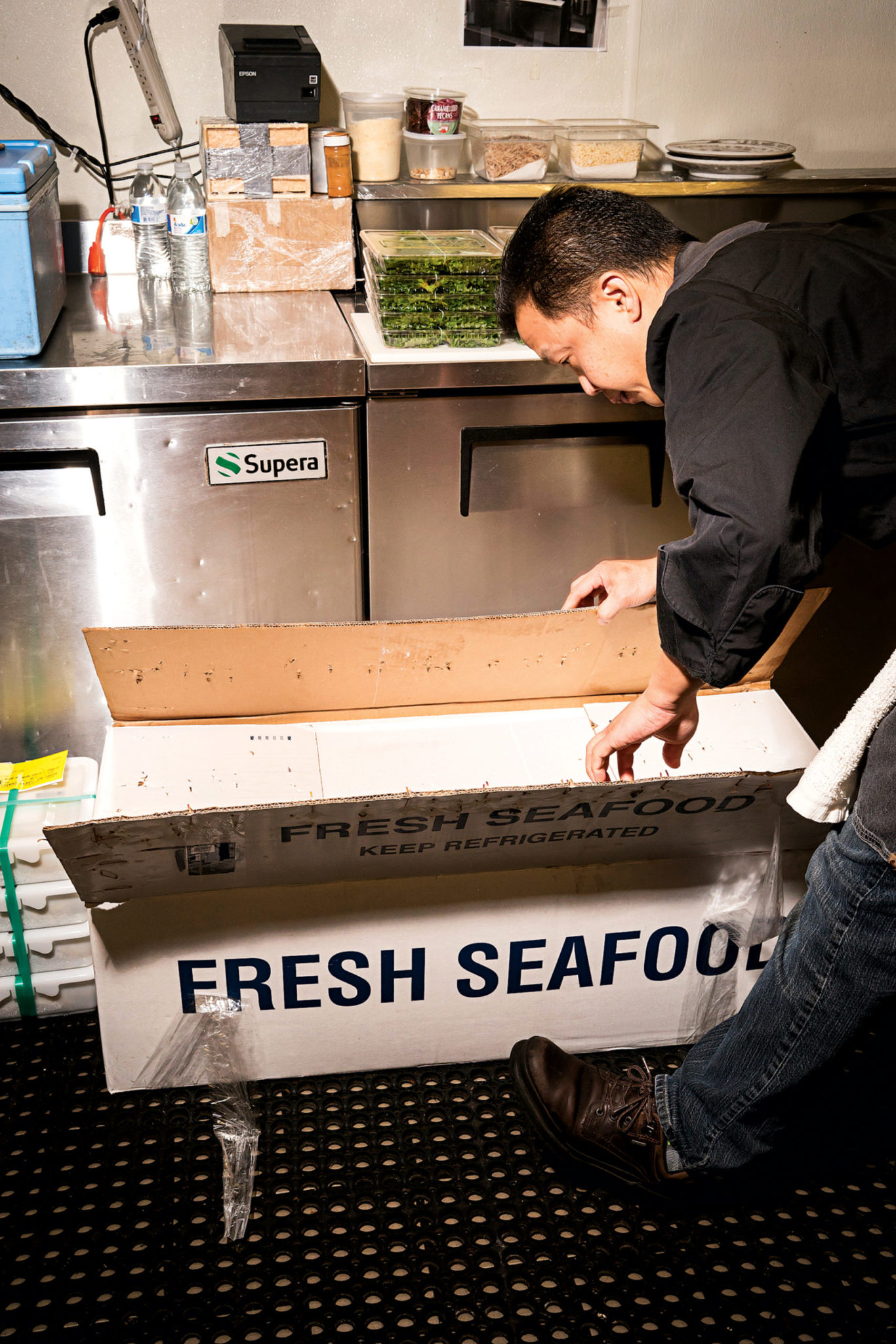 Piter inspects the daily shipment of seafood, most of which comes from Tokyo's famous Tsukiji market. Photograph by Scott Suchman.