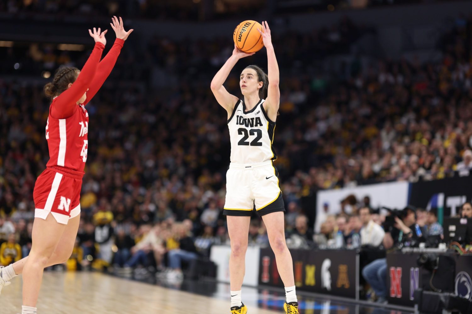 Caitlin Clark (right) takes a shot while playing for Iowa.