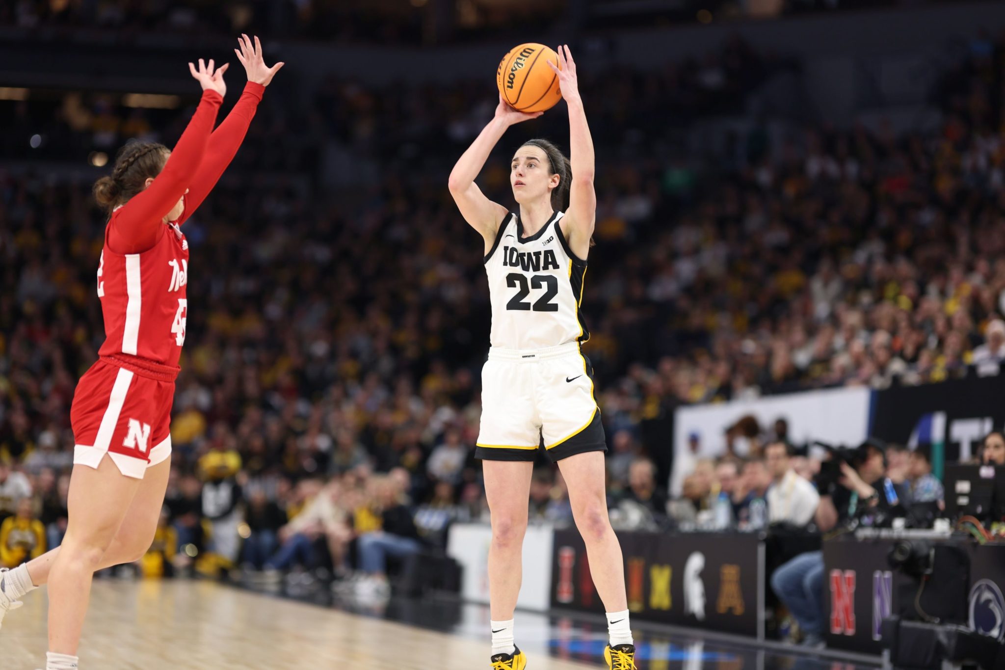 Caitlin Clark (right) takes a shot while playing for Iowa.
