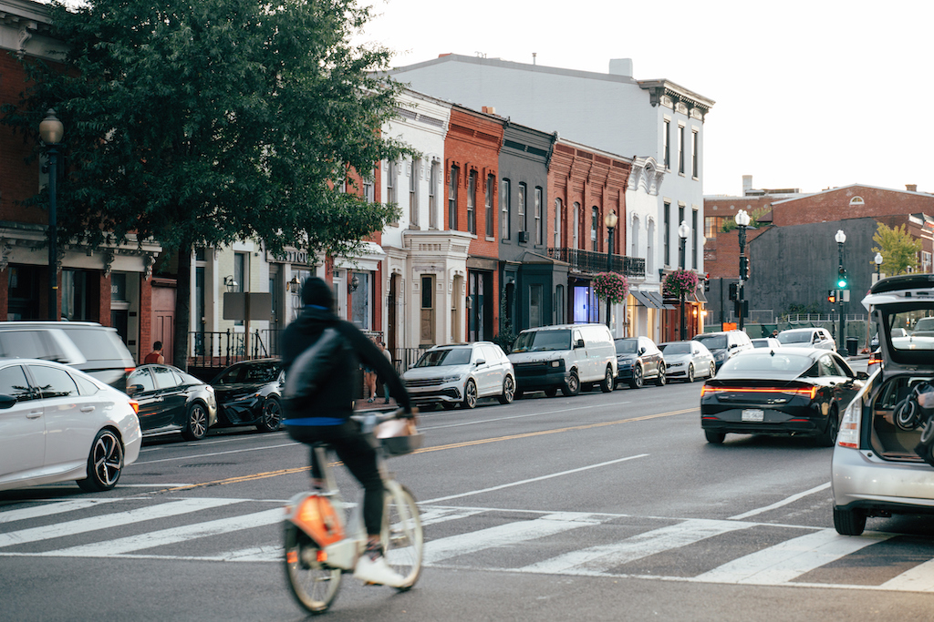 A cyclist rides through car traffic in Georgetown.